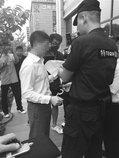 陈某被法警戴上手铐 记者/林琳 摄